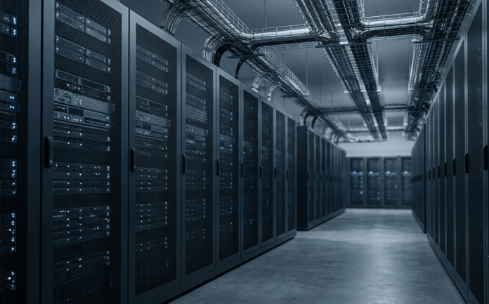 Cold aisle between rows of server cabinets in a modern enterprise data centre, with overhead fibre optic cabling.